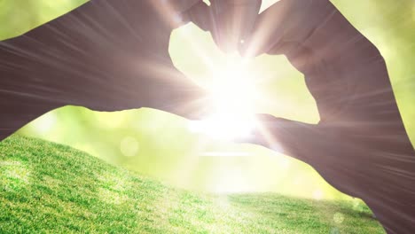 Digital-animation-of-human-hand-forming-a-heart-shape-against-sun-shining