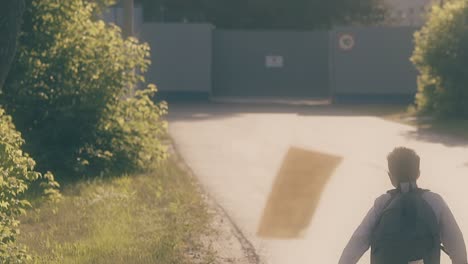 boy throws away paper sheets running to grey fence 1