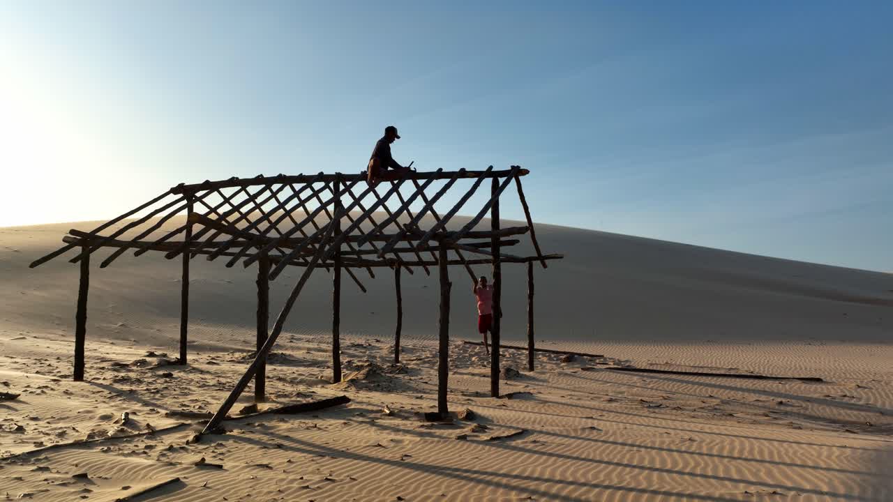A person on a partially built wooden structure, desert landscape, Araioses Parnaiba River