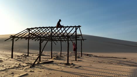 a person on a partially built wooden structure, desert landscape, araioses parnaiba river