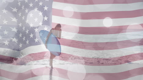 animation of american flag and light spots over caucasian woman carrying surfboard on sunny beach