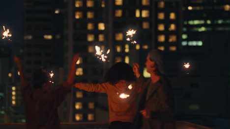 amigos felices sosteniendo bengalas celebrando la víspera de año nuevo en la azotea al atardecer divirtiéndose disfrutando de la celebración de fiestas navideñas