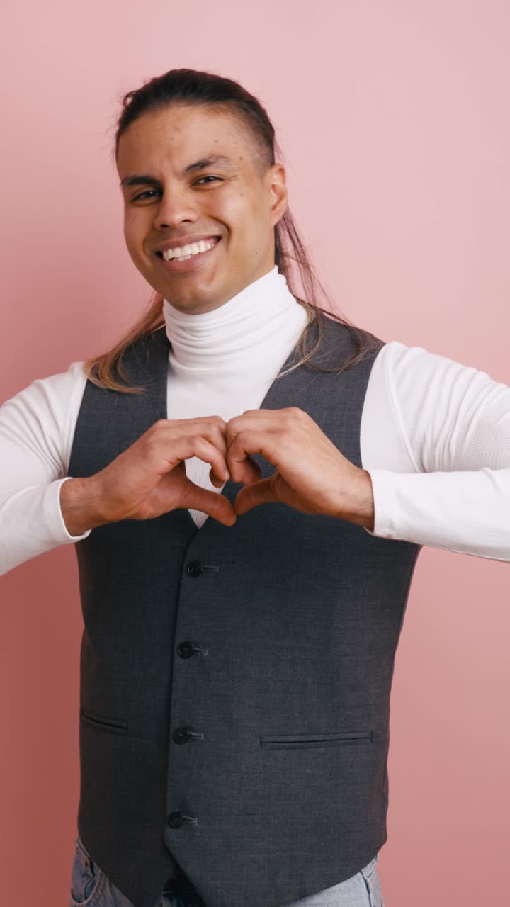 Uomo che manda un bacio e forma un cuore con le mani