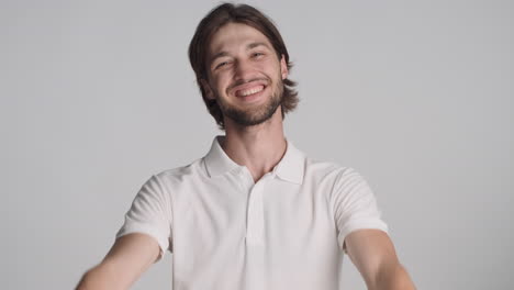 caucasian man in front of camera on gray background.