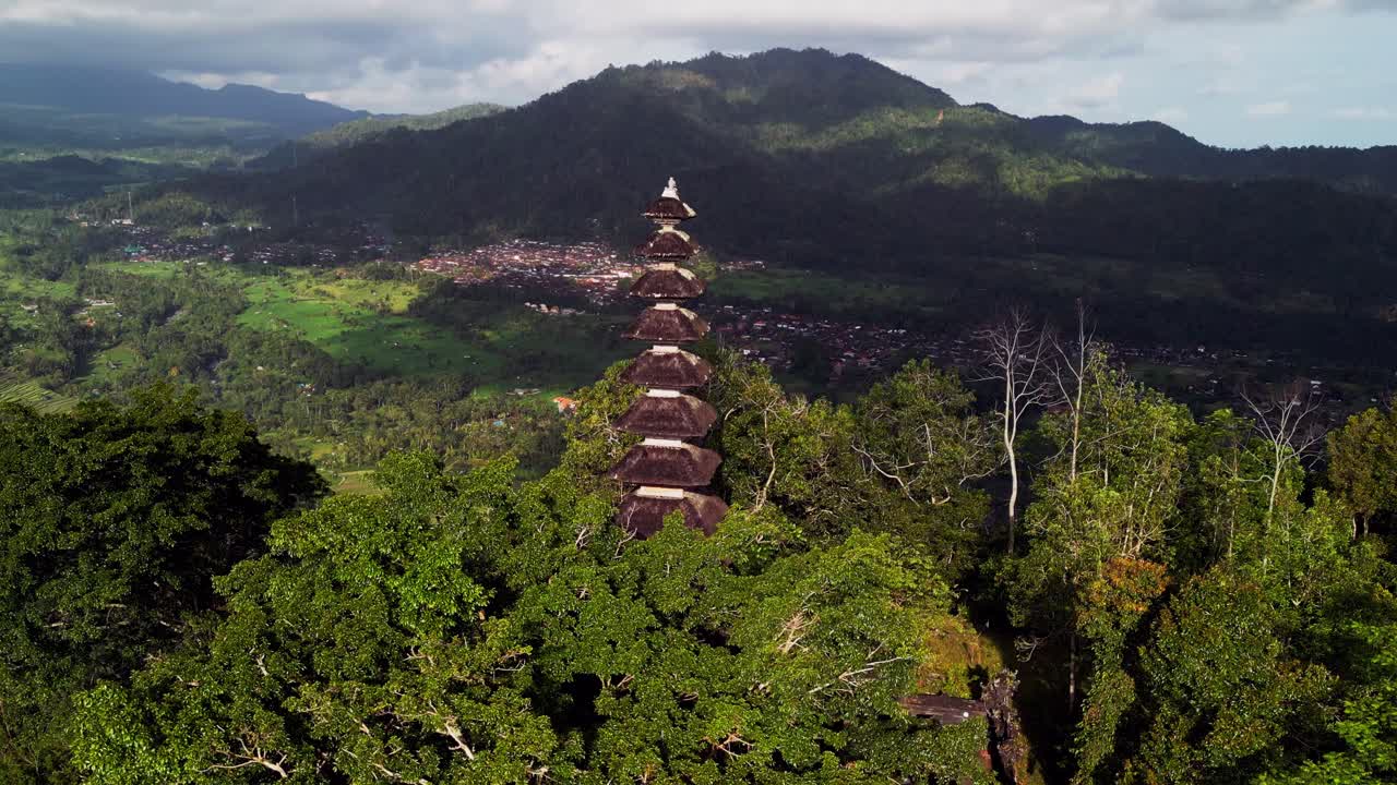 Drone footage of a sacred Balinese temple on the hills of Sidemen. The temple is surrounded by dense forest and mountain views, showing a natural balance between culture and landscape