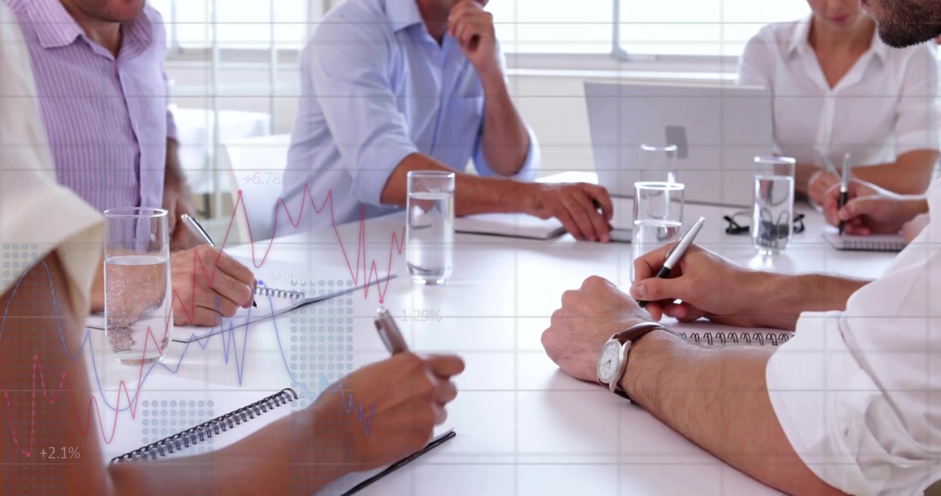 Team che inizia una riunione, scrivendo, sorseggiando, usando il telefono, mentre grafici sono mostrati sul tavolo per affari