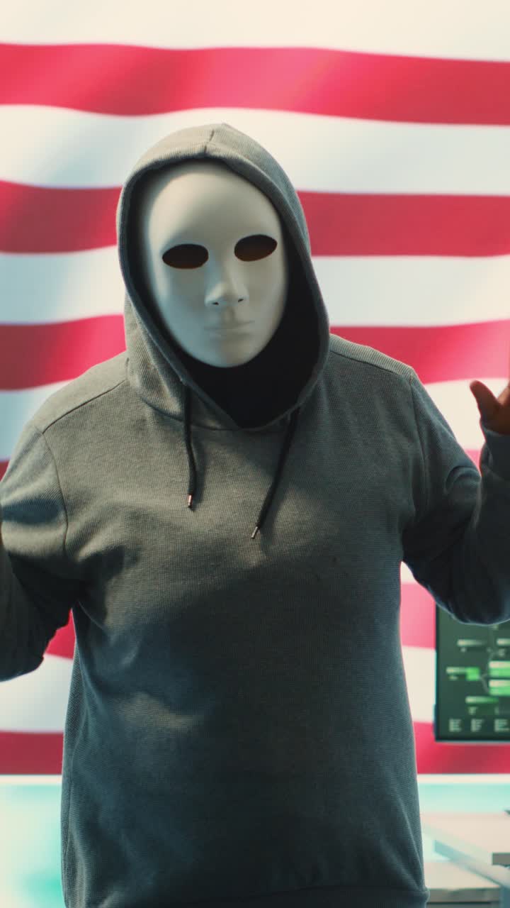 Persona anonima con maschera e felpa con cappuccio che registra un video per i social media