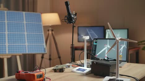 bright light into solar cell panel of wind turbine with a laptop being tested on the table next to the solar cell at the office