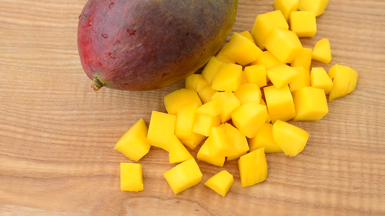 Pezzi di mango su un tagliere di legno. Riprese in movimento