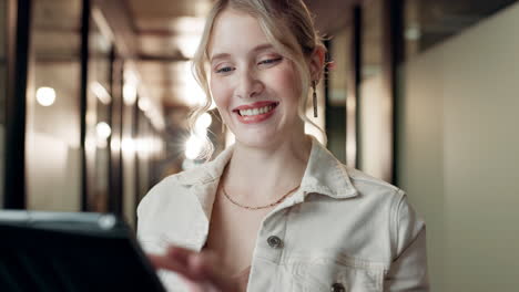 a smiling woman using a tablet in an office