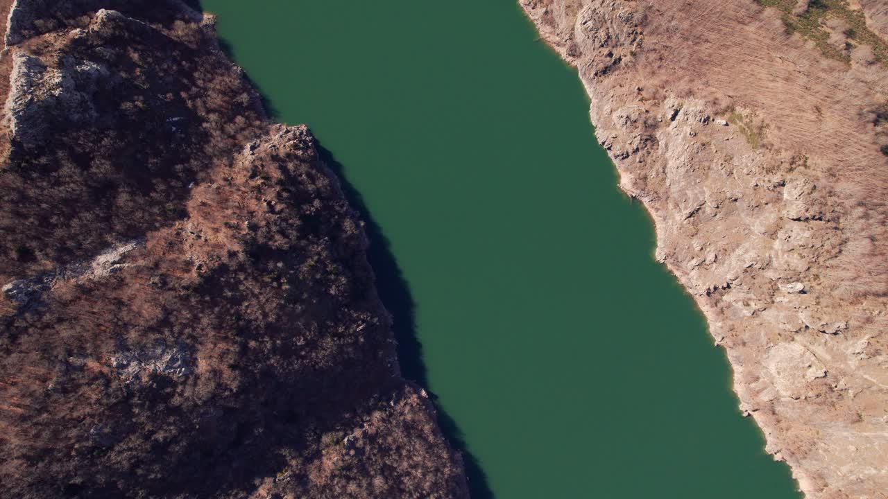 Aerial View of a Serpentine River Flowing Through a Rocky Canyon