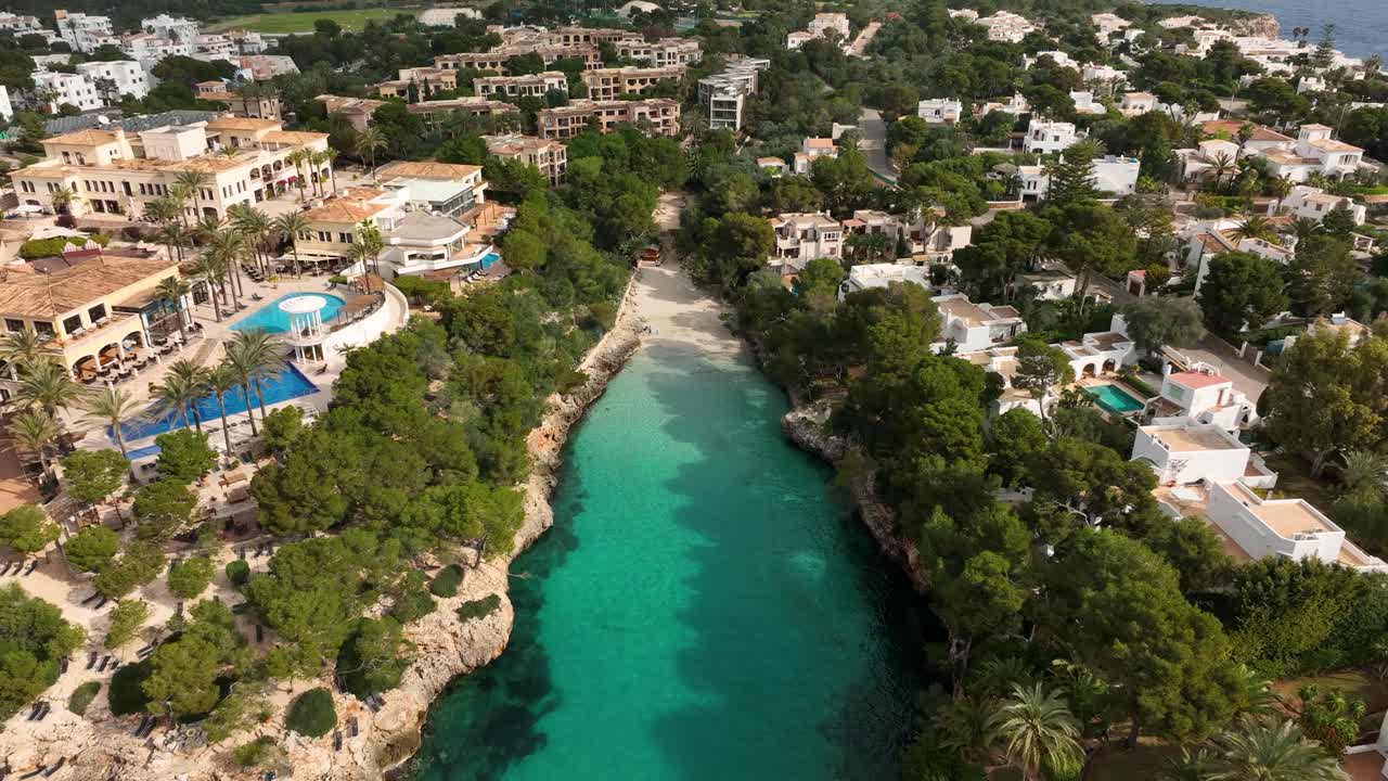 vista aérea de drones volando cerca de una pequeña playa en cala d'or, mallorca con aguas cristalinas