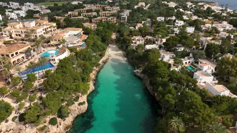 aerial view of drone flying close to a small beach in cala d'or, mallorca with crystal clear waters