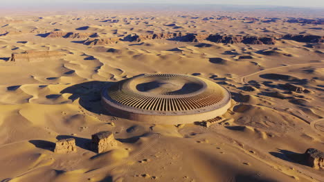 aerial view of a unique spiral building in a vast desert landscape