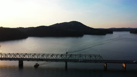 Amazing-aerial-footage-of-boats-passing-under-road-bridge-at-sunset