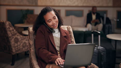 woman working on laptop and talking on phone in hotel lobby