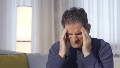 mature man with headache suffering at home.