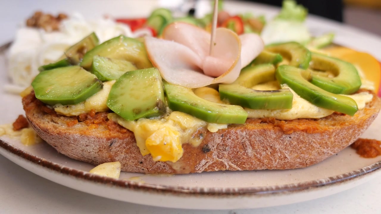Primo piano di una colazione gourmet con toast all'avocado e uovo