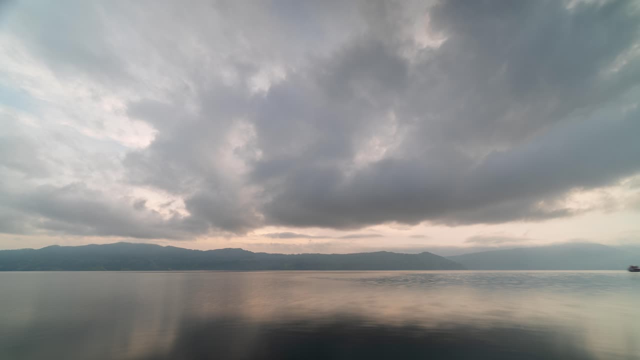 Serene Lake with Cloudy Sky and Mountain Reflections