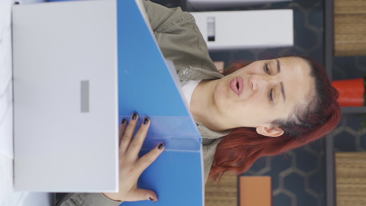 video vertical de una mujer de negocios exitosa trabajando felizmente en archivos de papeleo.