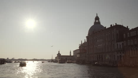 sailing towards basilica di santa maria della salute on a beautiful sunny morning, water reflections, venice, italy