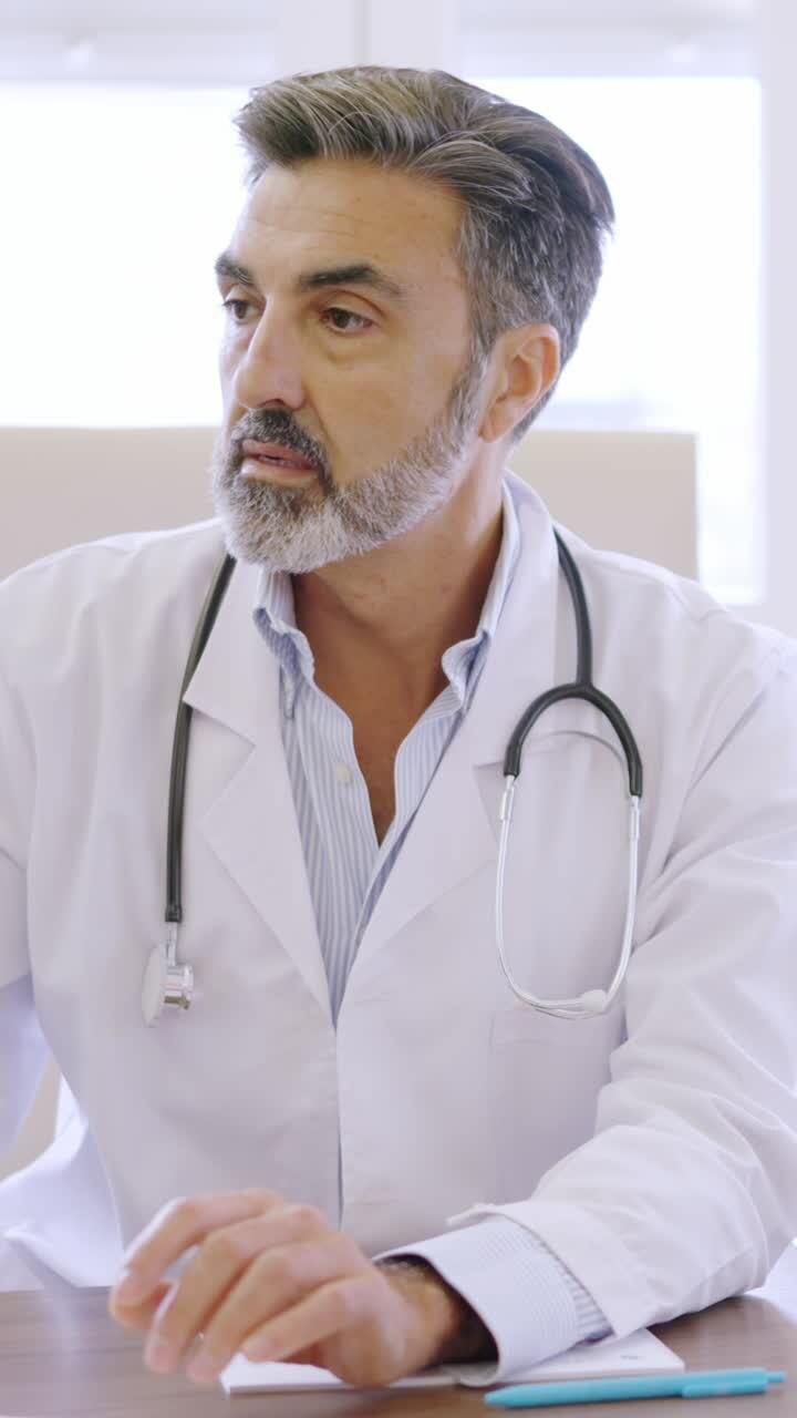 Doctor writing while talking with a patient in a clinic