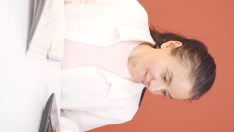 Vertical-video-of-Concentrated-woman-working-on-laptop.