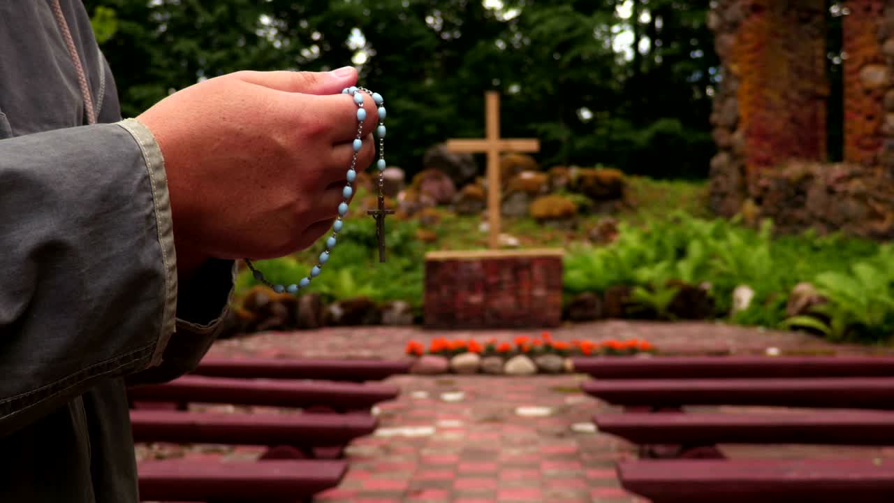 야외에서 십자가 근처에 주례를 가진 남자