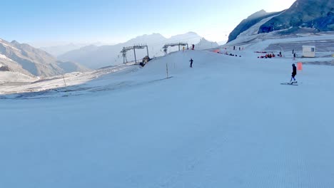 skiers in slalom on a ski slope in switzerland - pov