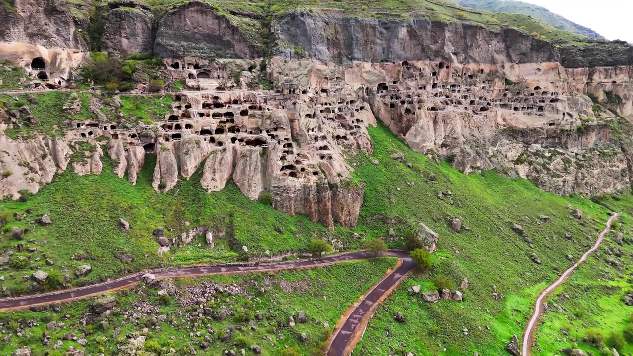 Güney Gürcistan'da, Kura Nehri'nin sol kıyısındaki Erusheti Dağı'nın yamaçlarından oyulmuş Vardzia mağara manastırı alanının havadan drone görünümü.