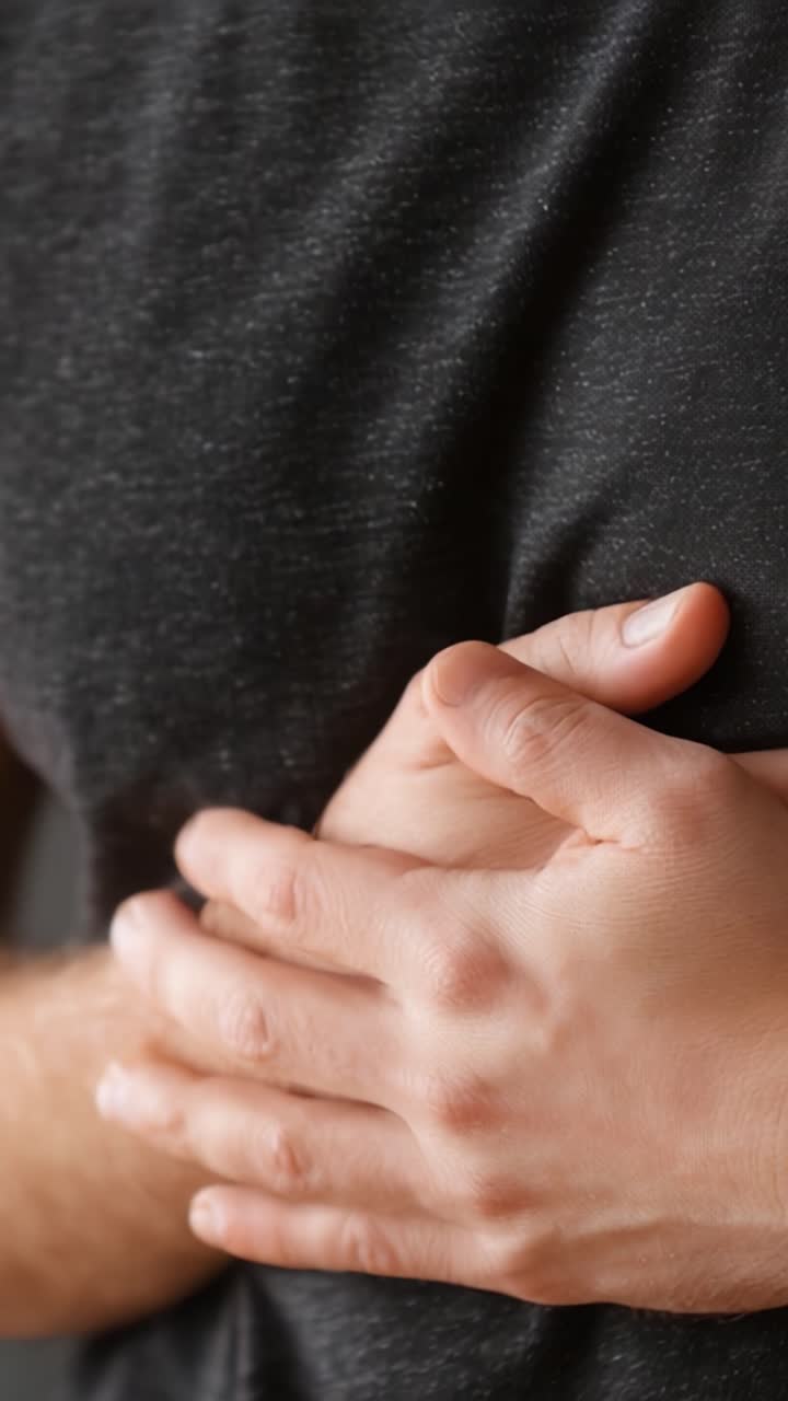穏やかな環境で、内省、感情、または脆弱性を象徴するように胸に手を当てるクローズアップ。