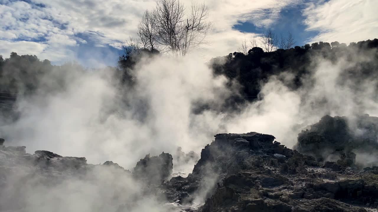 푸른 하늘과 함께 부분적으로 구름이 많은 날 화산 풍경에서 상승하는 지열 증기