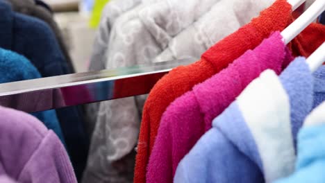 colorful bathrobes hanging on a rail in a store