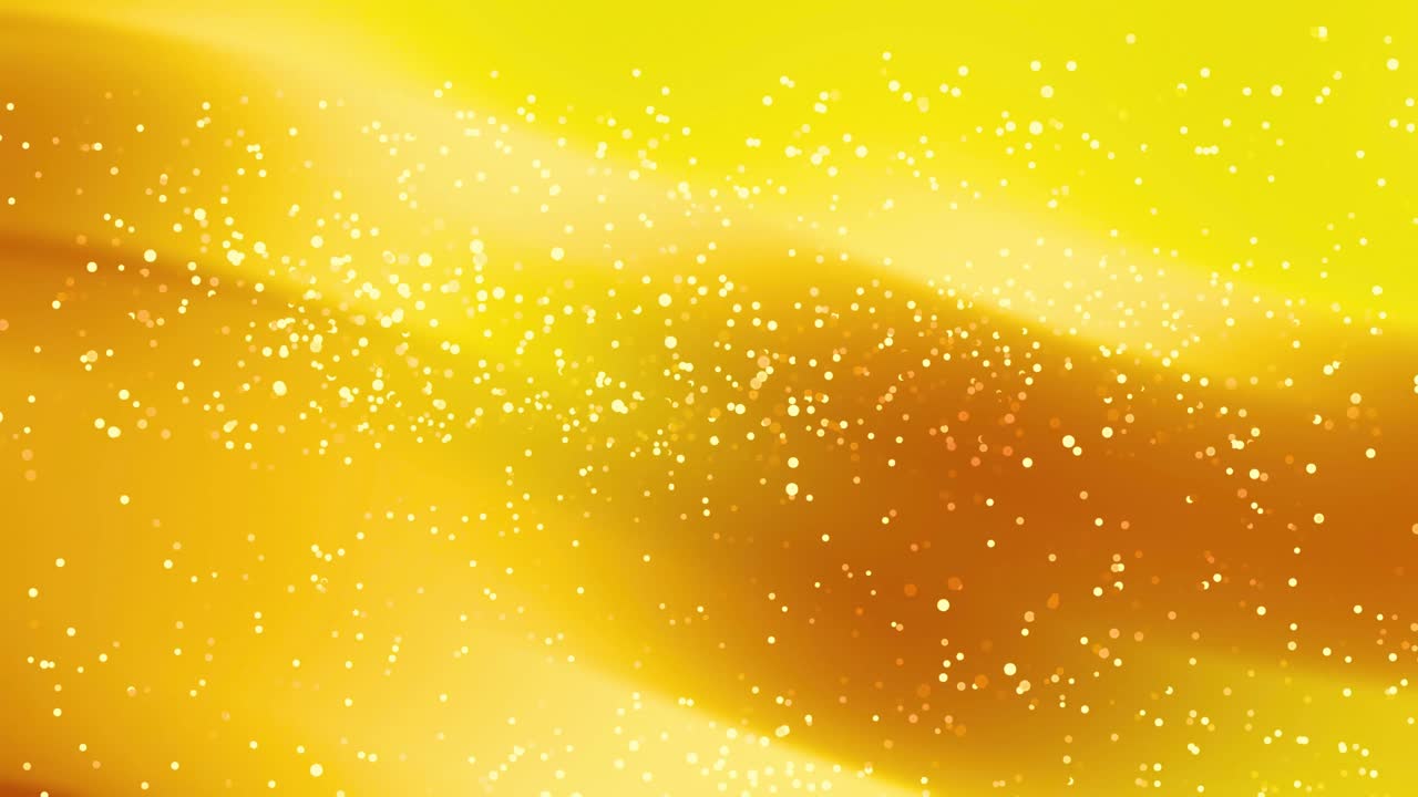 抽象的な黄橙色の背景にきらめく金色の粒子が漂う
