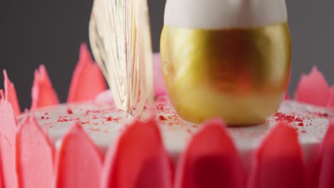 close-up view of a rotating cake adorned with roses on top, displaying vibrant colors such as red, pink, and white