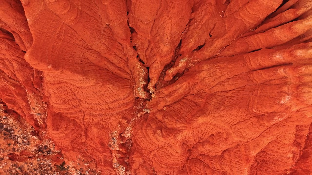 Fessura di canyon formata dall'erosione dell'acqua, Teruel, Aragona, Spagna. Prospettiva diretta dall'alto con drone di una stretta fessura nel terreno rosso brillante.