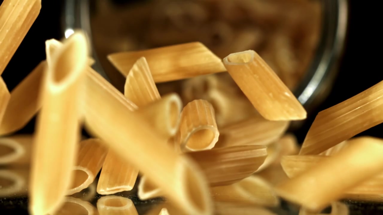 Pasta penne cruda che cade in super rallentatore