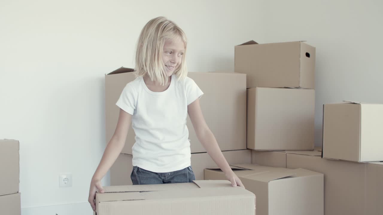 alegre niña de cabello claro posando en un nuevo apartamento
