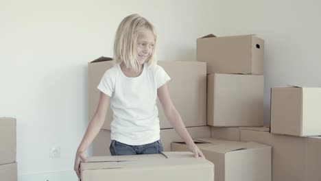 Cheerful-fair-haired-little-girl-posing-in-new-apartment