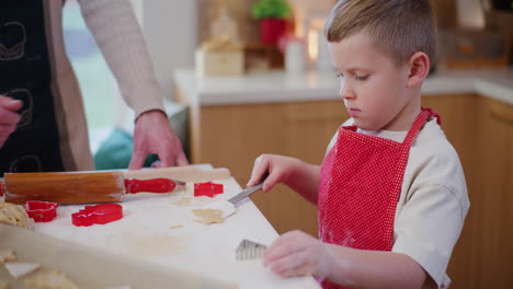 un niño ayuda a su padre con la cocción de las fiestas.