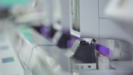 closeup of blood samples in tubes processed through automated hematology analyzing machine