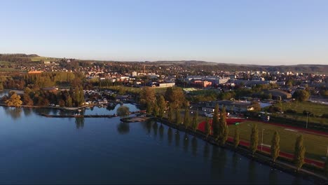 Vista-Aérea-De-La-Ciudad-De-Yverdon-les-bains,-Suiza,-Drone,-Lago,-Puesta-De-Sol