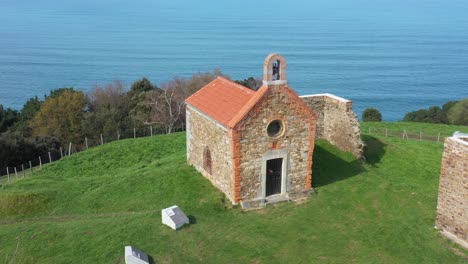 Aerial-drone-view-of-a-hermitage-next-to-the-Cantabrian-Sea-in-Deba-in-the-Basque-Country