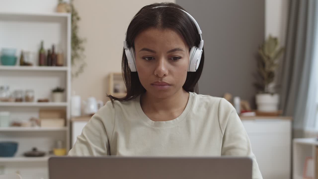 Woman working on laptop with headphones