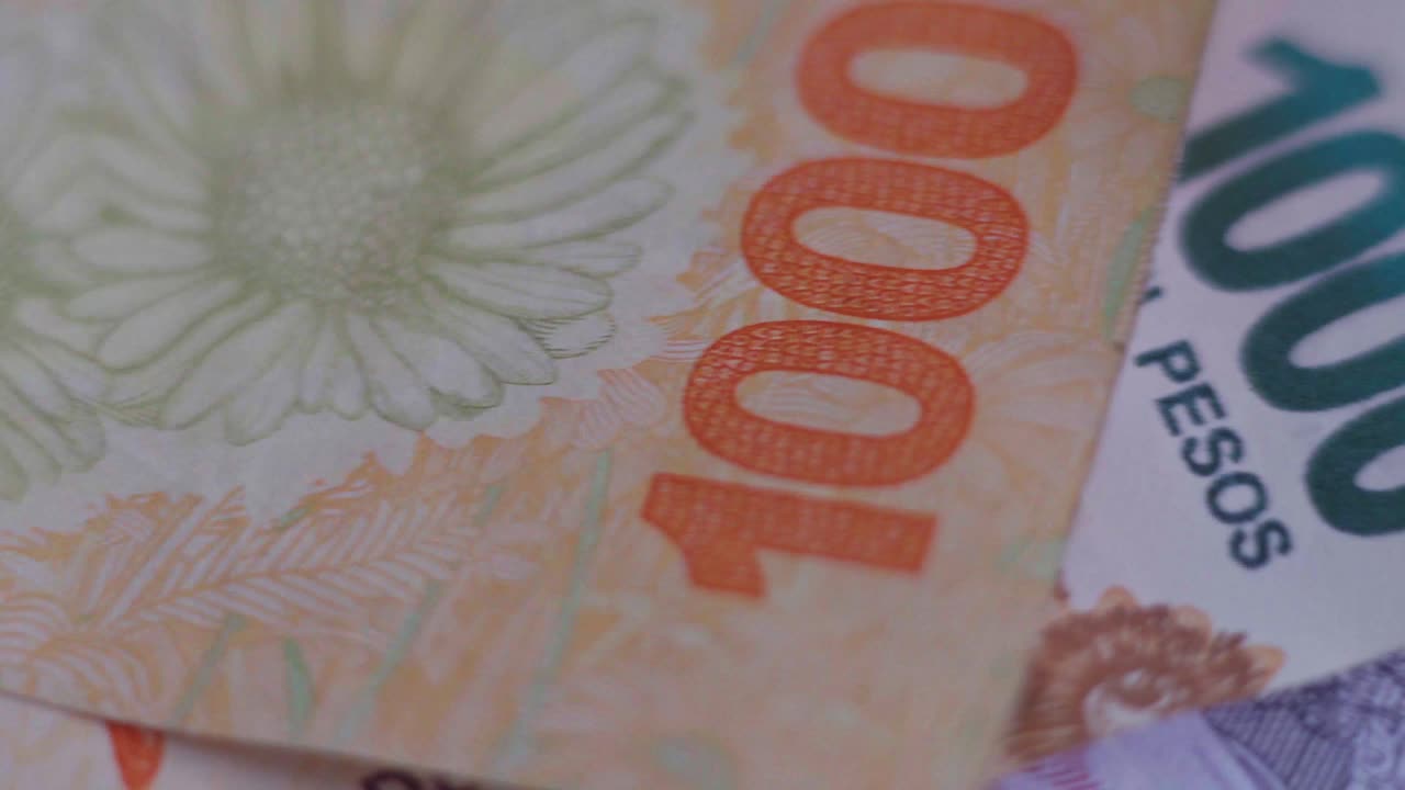 primer plano de billetes argentinos de diferentes denominaciones, desplazándose de izquierda a derecha