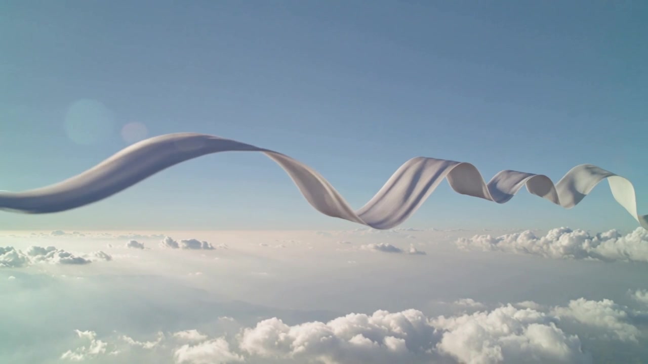 Lungo nastro di tessuto bianco ondeggiante che si muove con il flusso d'aria sopra nuvole cumuliformi, con bagliore dell'obiettivo.