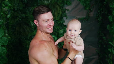 loving dad kisses his cute little baby. father tosses his son up and the kid is smiling happily.