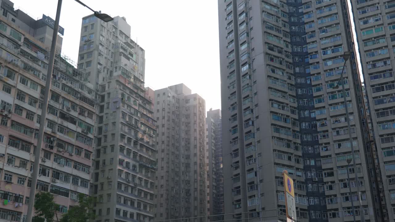 Vista panorámica de edificios de apartamentos y rascacielos en el centro de Hong Kong, China, en un día soleado, mostrando la densa vida urbana y la arquitectura moderna.