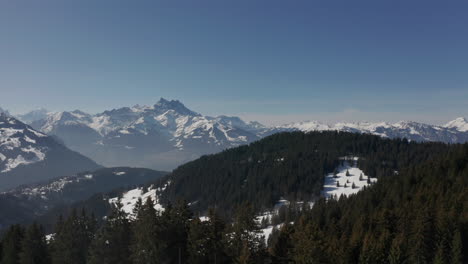 aerial of beautiful snow covered valley with green forests