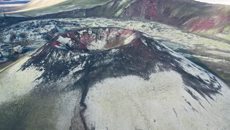 aerial: circle view of green and red dormant and vibrant volcano on a clear day in iceland highlands